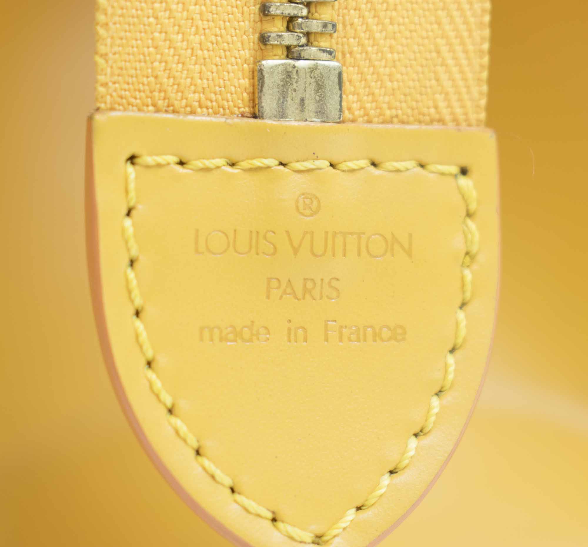 LOT:353  LOUIS VUITTON - a yellow Epi Sac Triangle handbag.