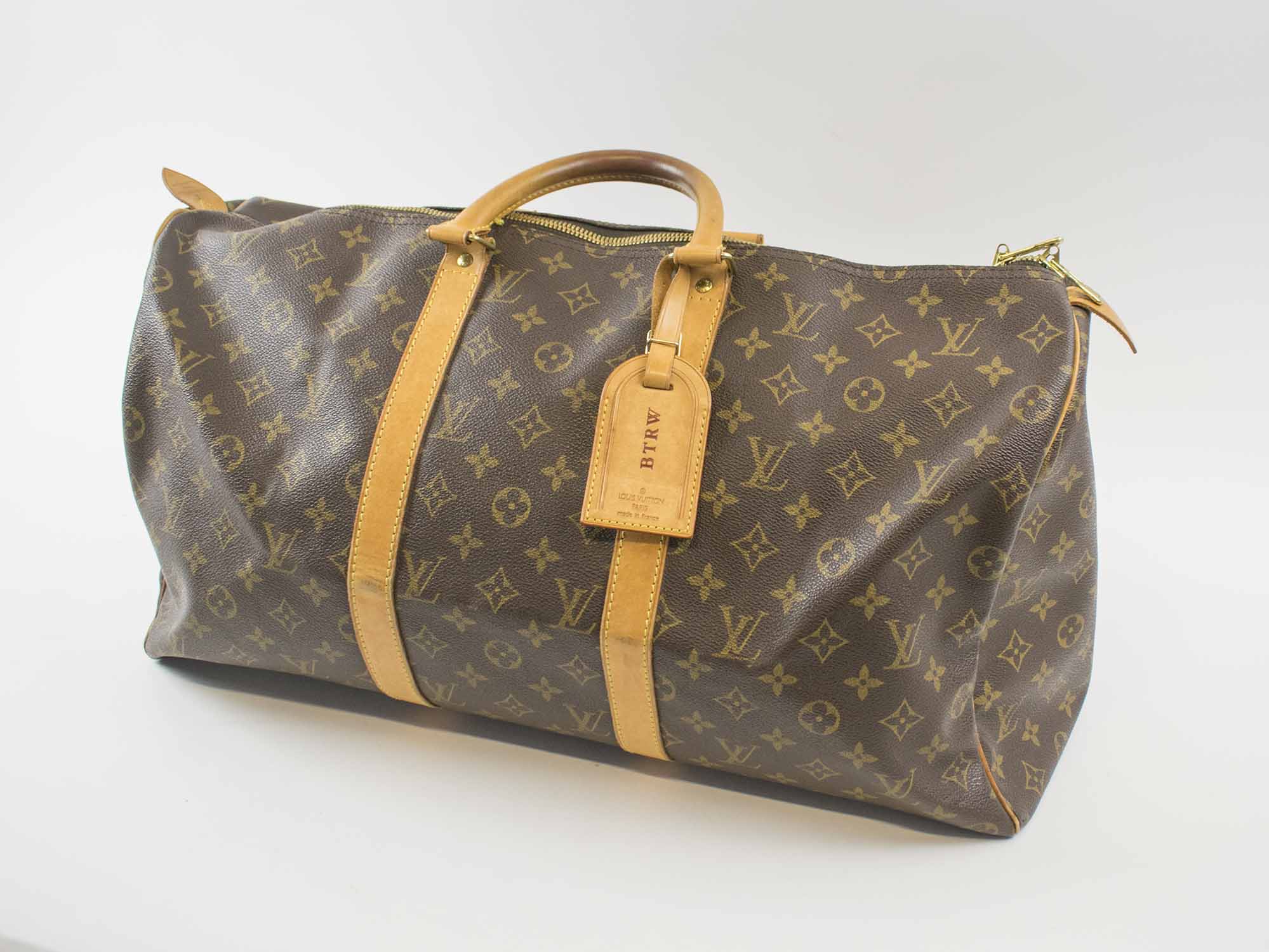 LOUIS VUITTON KEEPALL 50 TRAVEL BAG, monogram canvas with full top double  zip closure, two top handles with leather trims and leather tag with  B.T.R.W. initials, 50cm x 27cm x 22cm.