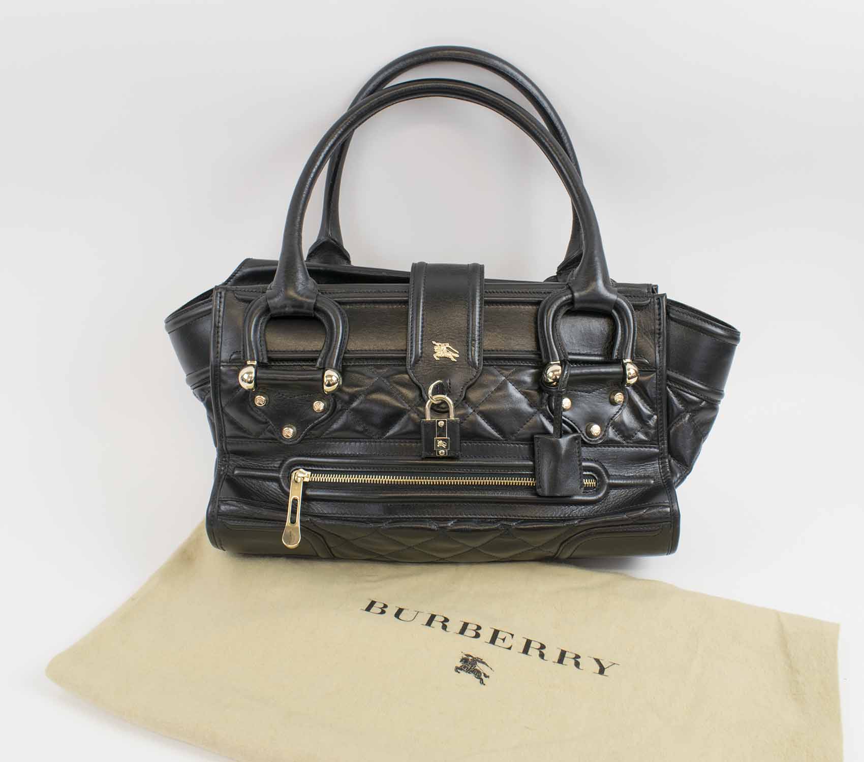 BURBERRY MANOR BAG, black quilted leather with pale gold tone hardware, two  top handles, top zip closure, front closure strap with padlock and key, zip  front pocket, fabric lining, with dust bag