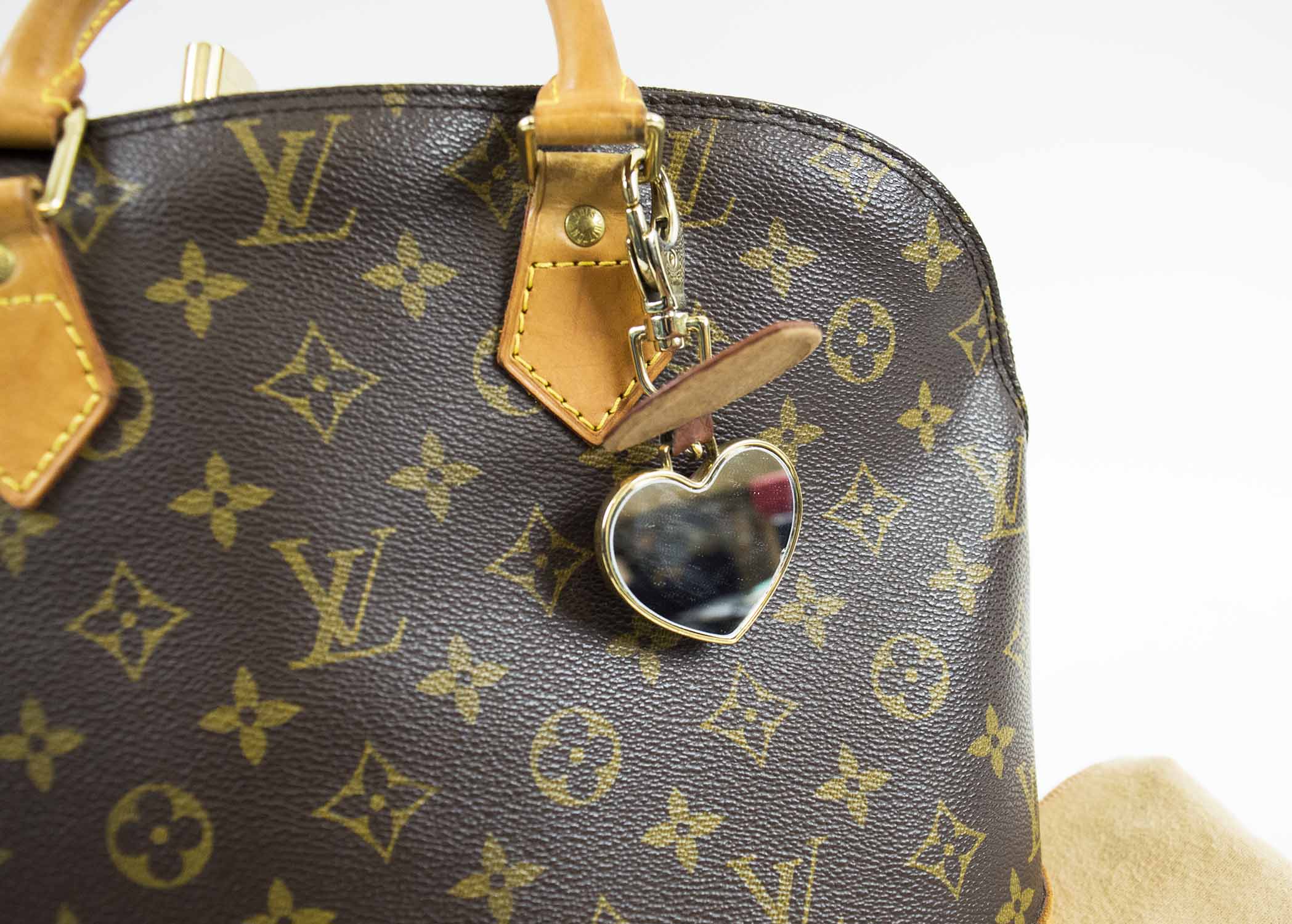 LOUIS VUITTON ALMA BAG, monogram canvas with two top vacchetta leather  handles and trims, double zip with padlock closure and two keys, key ring  charm, brass tone hardware, fabric lining with dust
