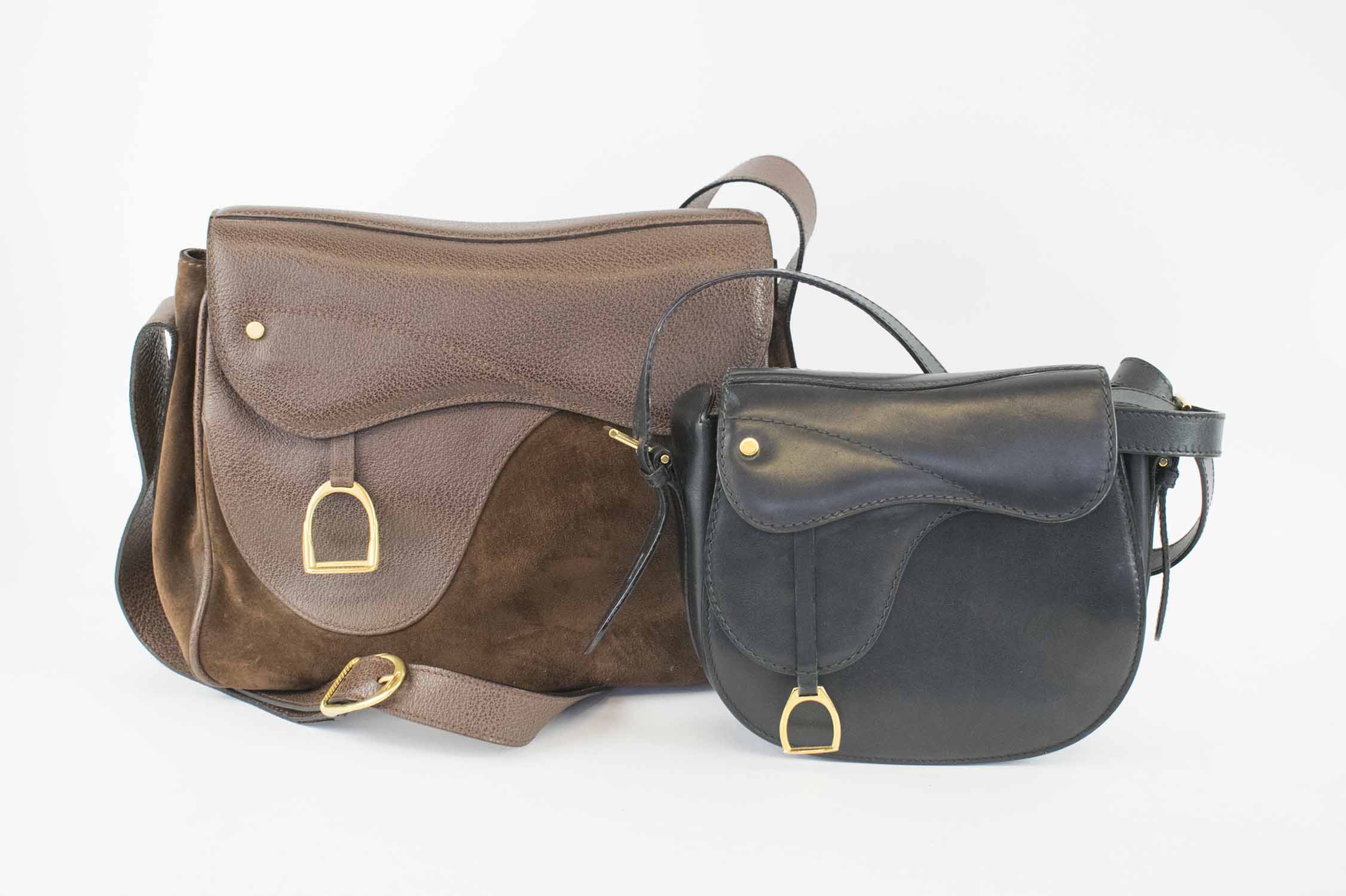 GUCCI SADDLE BAGS, with equestrian stirrup charm, one leather and suede 30cm 23cm H x 12cm, the other black leather 20cm x 18cm H x 6cm both with adjustable