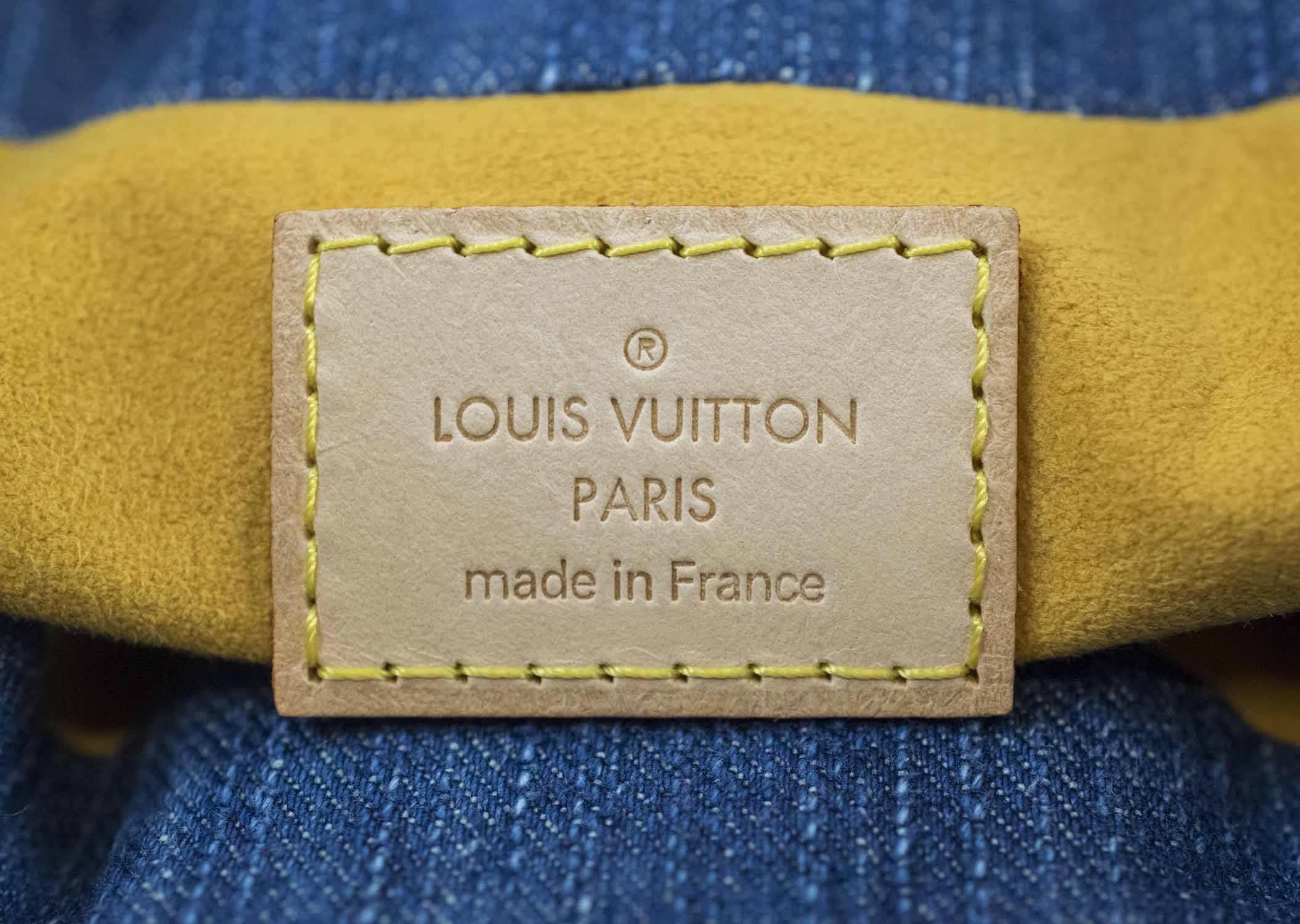LOUIS VUITTON DENIM HANDBAG, monogram denim with leather trims and handles,  gold tone hardware, push clasp front closure and snap closure at both  sides, 25cm x 15cm H with dust bag and